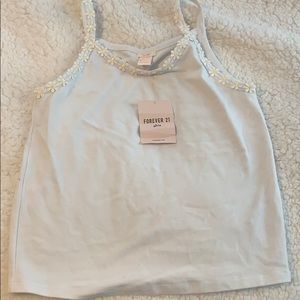 A girls tank top with daisy flowers on the straps.